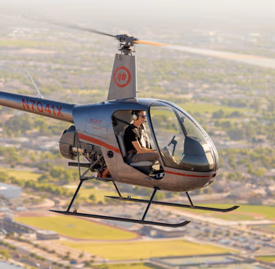 Air-to-air photo of student solo pilot flying Robinson R22 during morning flight training over Chandler, Arizona Student solo pilot flying Robinson R22 helicopter over Chandler, Arizona during training